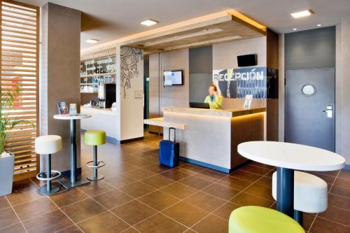 a woman sitting at a counter in a restaurant at Ibis Budget Madrid Getafe in Getafe