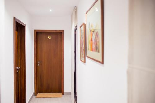 a hallway with a door and pictures on the walls at La Varangue in Antananarivo