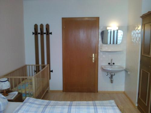a bathroom with a wooden door and a sink at Appartement Hinterleiten in Wagrain