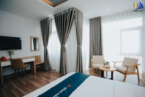 Habitación de hotel con cama, escritorio y TV. en Dong Hai Hotel _ Rach Gia, en Rạch Giá