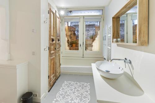 a bathroom with a white tub and a sink at De Verrassing aan de Werf in Utrecht