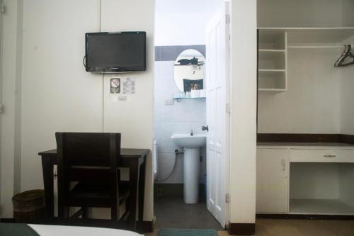 a bathroom with a sink and a tv on the wall at Isla Gecko Resort in Boracay