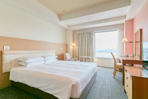 a hotel room with a large bed and a desk at Hotel Seagull Tenpozan Osaka in Osaka