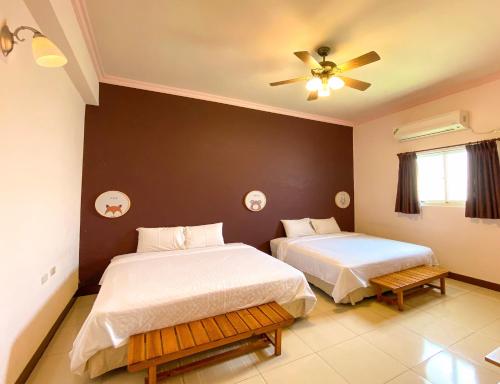 um quarto com duas camas e um ventilador de teto em Penghu Jack Family B & B em Magong