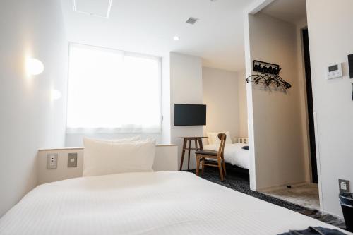 a hotel room with a bed and a desk at Hotel Potmum Sapporo in Sapporo