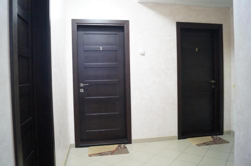 two black doors in a room with a tile floor at Rosinka in Ukrayinka