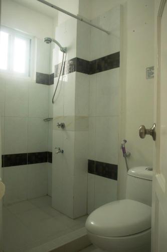a bathroom with a toilet and a glass shower at Isla Gecko Resort in Boracay