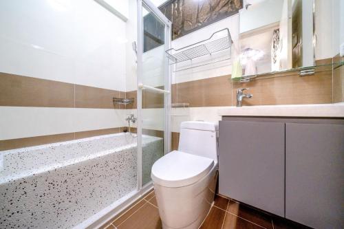 a bathroom with a toilet and a sink and a tub at 真愛民宿-寵物友善-近東大門夜市-含車位 in Hualien City