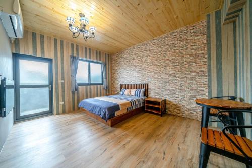a bedroom with a bed and a brick wall at 真愛民宿-寵物友善-近東大門夜市-含車位 in Hualien City