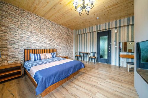 a bedroom with a bed and a brick wall at 真愛民宿-寵物友善-近東大門夜市-含車位 in Hualien City