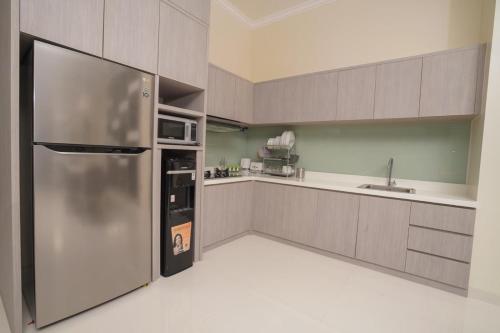 a large kitchen with a stainless steel refrigerator at Marseillia Hills in Puncak