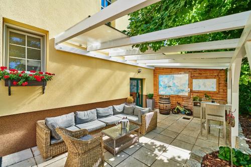 a patio with a couch and chairs and a table at Pension Kral in Rust