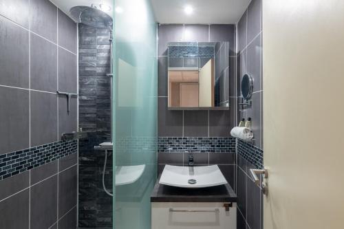 uma casa de banho com um lavatório e um espelho em StayParis em Issy-les-Moulineaux
