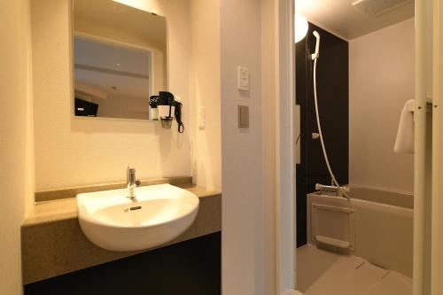 Hotel Wisteria NARA في نارا: حمام مع حوض أبيض ودش