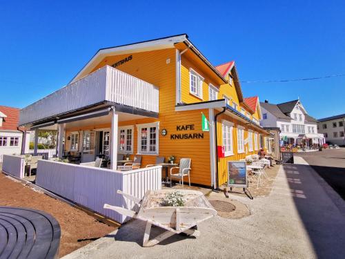 a yellow building with a table in front of it at Henningsvær Guesthouse in Henningsvær