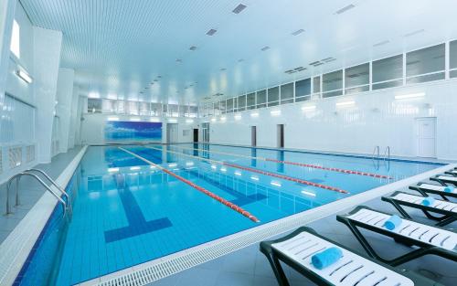 a large indoor swimming pool with blue water at Vozdvizhenskoe Park Hotel in Serpukhov