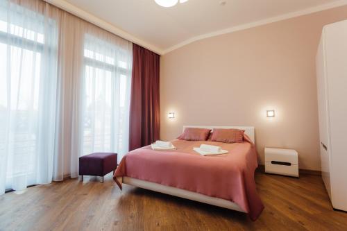a bedroom with a bed and a large window at Nicole in Uzhhorod