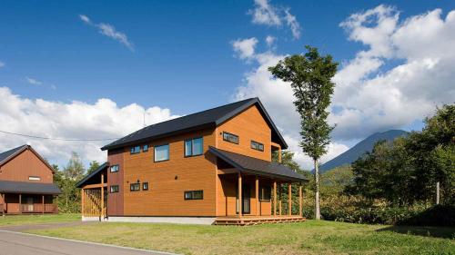 a large wooden house with a black roof at Country Resort Niseko in Kutchan