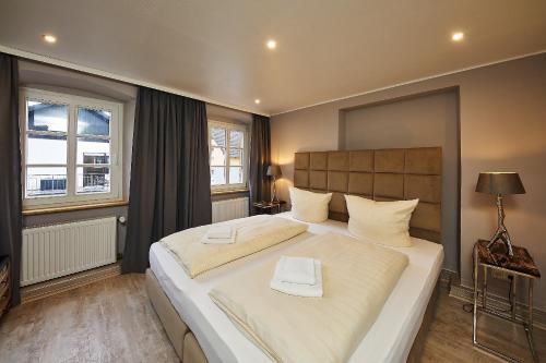 ein Schlafzimmer mit einem großen weißen Bett in einem Zimmer in der Unterkunft Winzerhaus Wehlener Sonnenuhr in Bernkastel-Kues