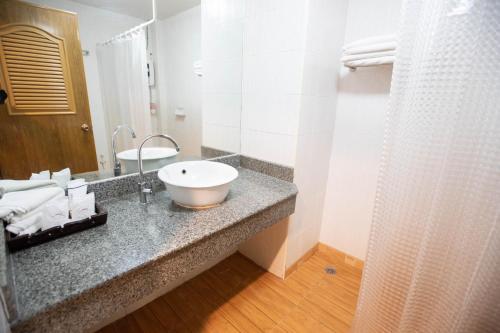 a bathroom with a white sink and a shower at Luckswan Resort Chiang Rai - SHA Extra Plus in Chiang Rai