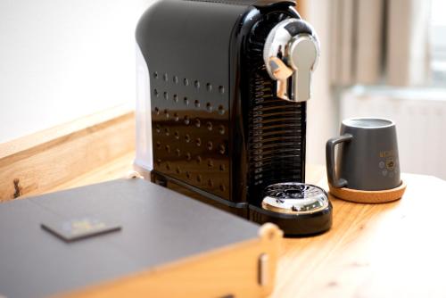 una tostadora sentada en una mesa junto a una taza de café en Holzfellas Home, en Wiesau