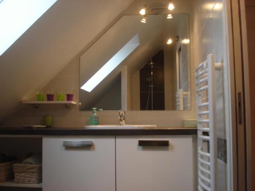 a bathroom with a sink and a large mirror at Ti Bihan - Meublé in Santec