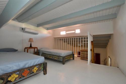 a bedroom with two beds and a staircase at Seru Coral Apartment in Willemstad