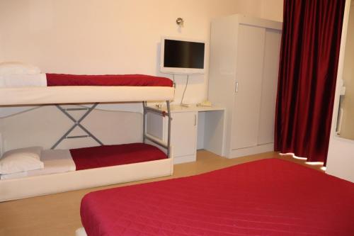 a room with two bunk beds and a television at Hotel Morolli in Rimini