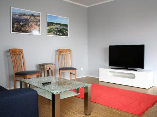 a living room with a table and a flat screen tv at Ferienwohnung Penthaus ILSE in Großräschen