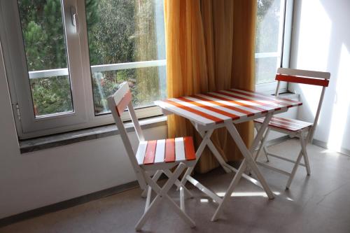 una mesa y dos sillas frente a una ventana en Hi Espinho - Pousada de Juventude, en Espinho