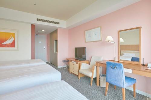 a hotel room with two beds and a desk with a computer at Hotel Seagull Tenpozan Osaka in Osaka