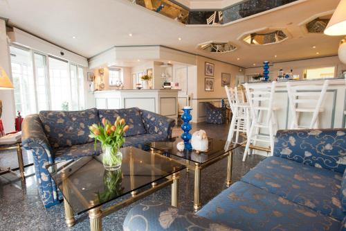 a living room with a couch and a glass table at Hotel Friesenhof in Norderstedt