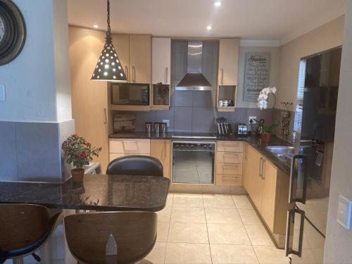 a kitchen with a table and chairs in it at Sands Beach Simbithi Eco Estate Luxury Villa in Ballito