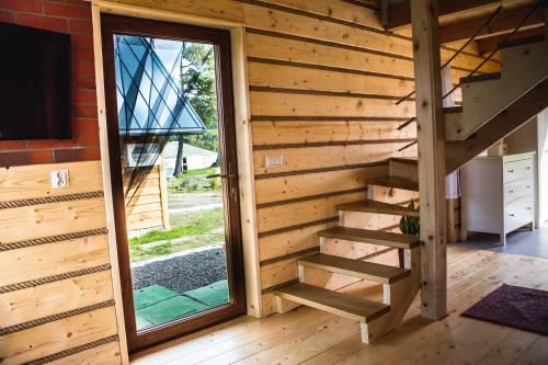 a room with a wooden wall with a staircase and a window at Chutor Grzegorza in Wysowa-Zdrój