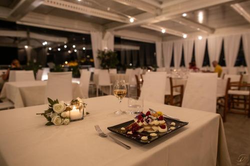 a table with a plate of food and a glass of wine at Hotel Monte Sarago in Ostuni