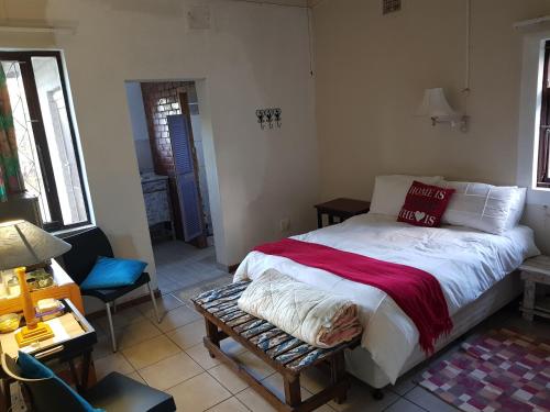 - une chambre avec un lit et une couverture rouge dans l'établissement Fairway cottage, à Port Edward