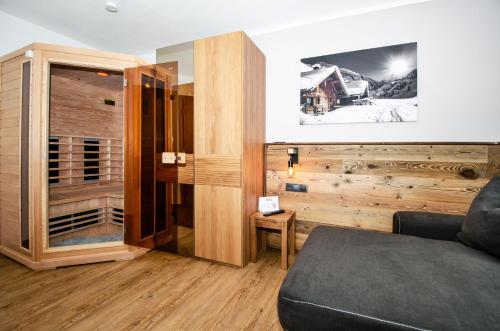 a living room with a couch and a wooden wall at Kitz Juwel Top 2 in Hollersbach im Pinzgau