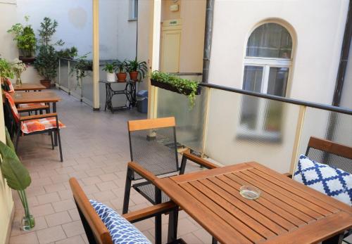 a balcony with wooden tables and chairs on a building at Self-service Hotel Ostaš Praha in Prague