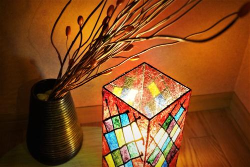 a vase with a stained glass cube next to a lamp at Ryokan Shimizu in Kyoto