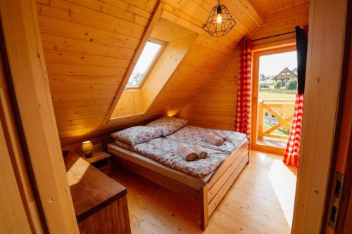Habitación con cama en una cabaña de madera en Widokowa Chata Istebna Trójwieś en Istebna