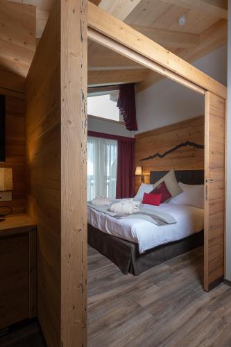 a bedroom with a large bed in a wooden room at Mont Chalet Nevada - Hotel & Spa in Livigno