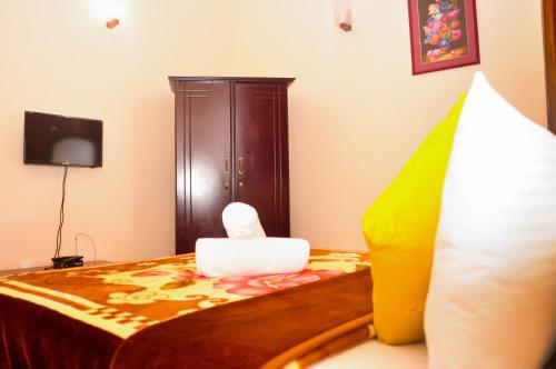 a bedroom with a bed with a wooden cabinet at New Kandy Residence in Kandy