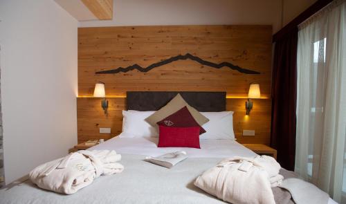 a bedroom with a bed with towels on it at Mont Chalet Nevada - Hotel & Spa in Livigno