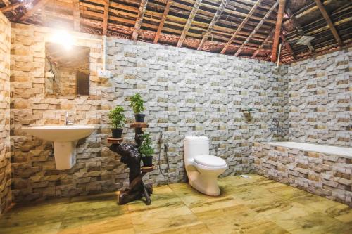 a bathroom with a sink and a toilet and a bath tub at Palm Trees Ayurvedic Heritage in Patnem