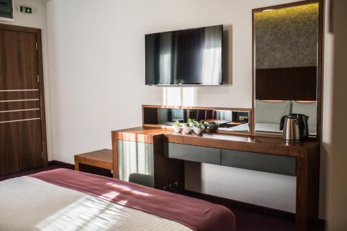 a hotel room with a desk and a sink at Hotel Bograd - Apartments & Lounge Station in Struga