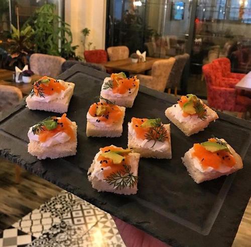 a bunch of sushi on a black plate on a table at Lagun Palas in Yalova