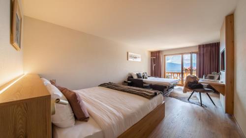 ein Hotelzimmer mit einem Bett und einem Schreibtisch in der Unterkunft VIU Hotel Villars in Villars-sur-Ollon