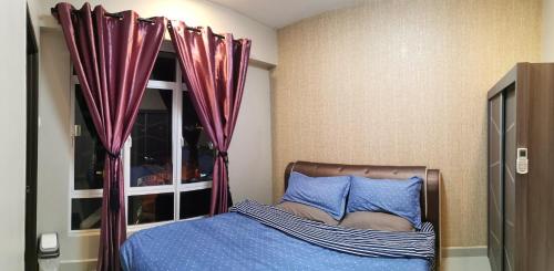 a bedroom with a bed and a window with purple drapes at Ipoh Central Homestay @ Majestic in Ipoh