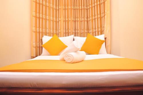 a bedroom with a bed with yellow and white pillows at New Kandy Residence in Kandy