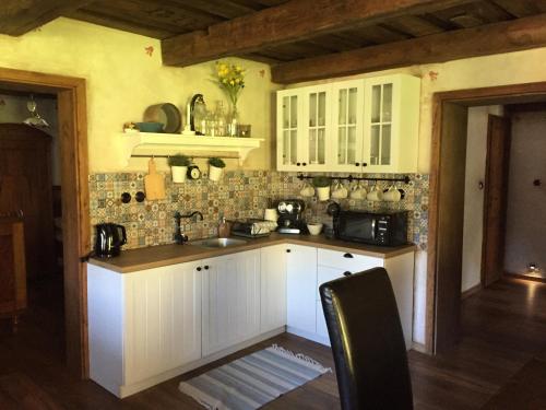 a kitchen with white cabinets and a counter top at Kazmarka in Malá Morávka